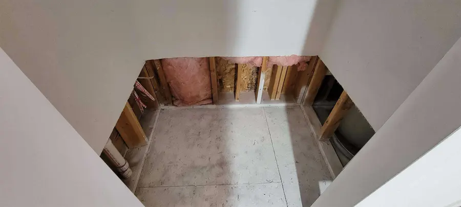 Flood-cut drywall exposing studs and insulation in an empty Aliso Viejo room during drying