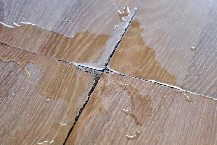 Water beading on wood floor boards and seeping into the seams after a leak